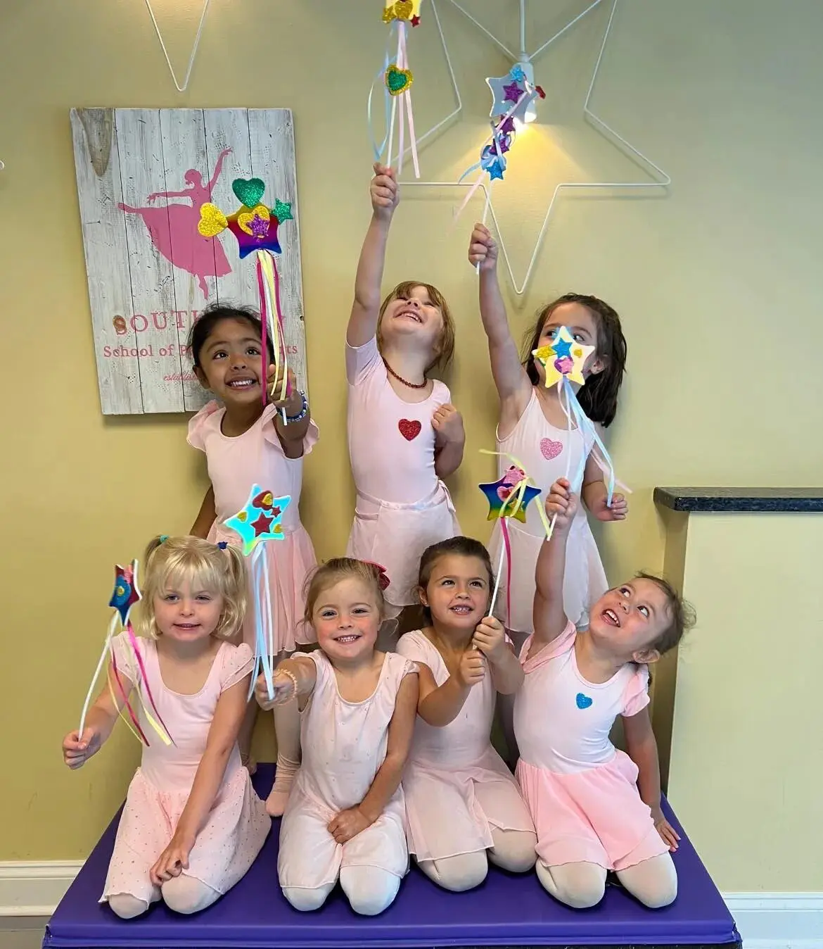 A group of young girls in pink and white outfits.